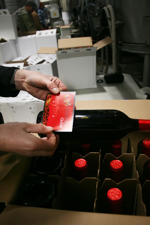 Hand labeling Glogg wine at Pedernales Cellars 