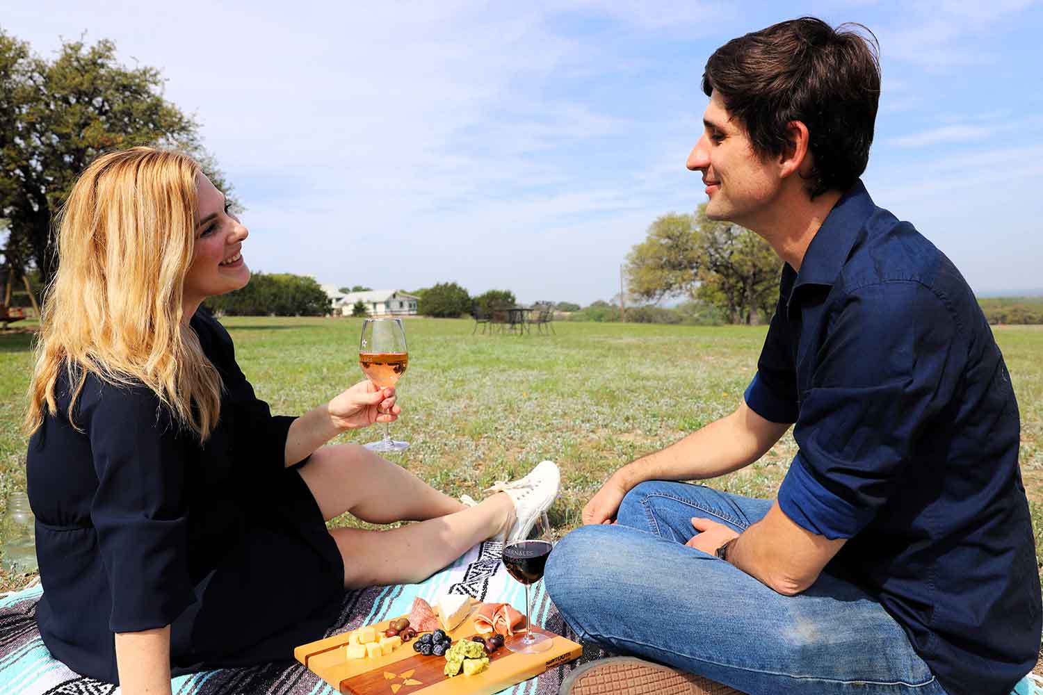 Two people pinicing on the lawn at Pedernales Cellars Simple Summer Wine and Picnic Pairings